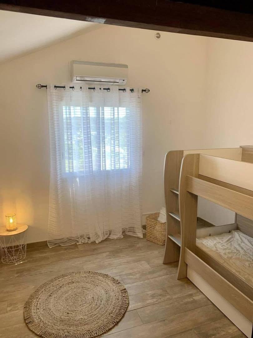 Chambre enfants avec lits superposés et tapis en jonc de mer
