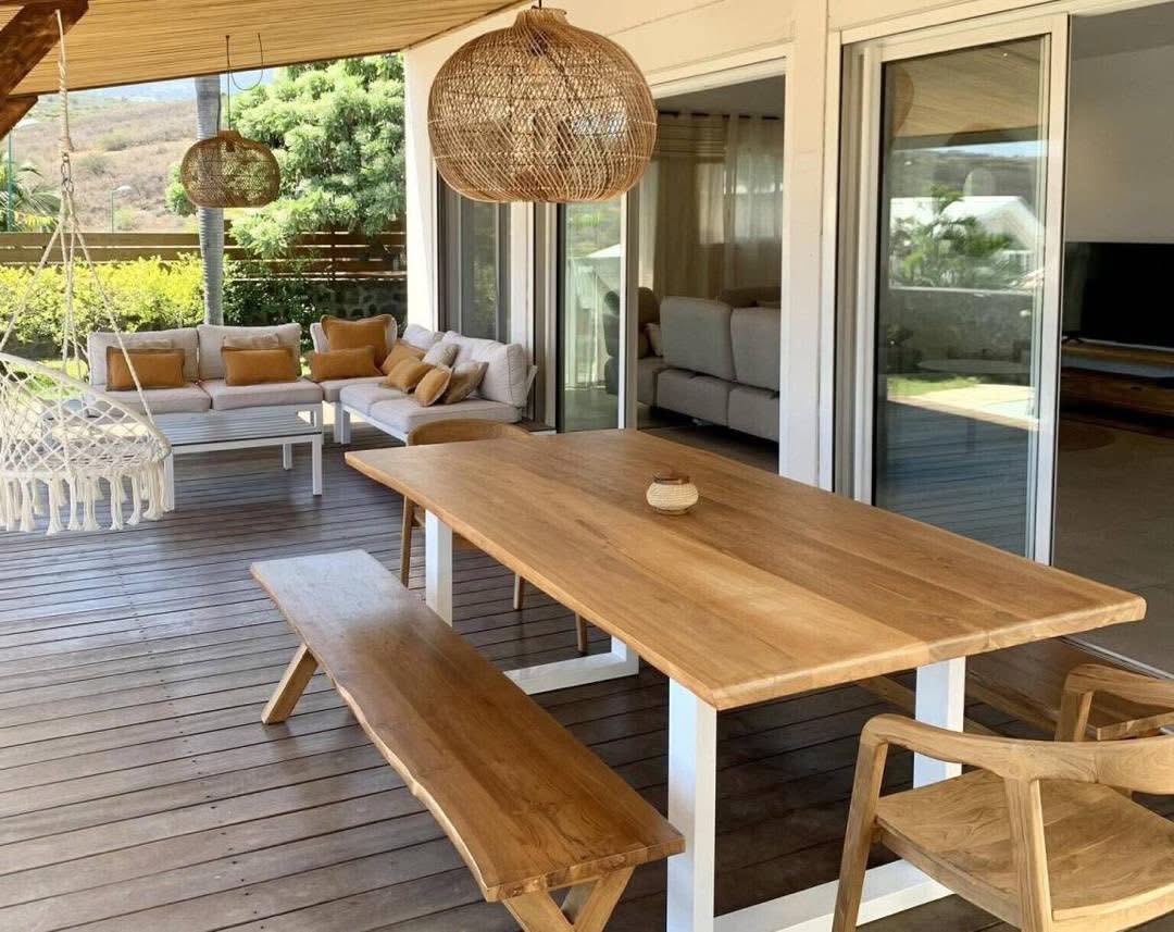 Varangue avec grande table en bois, banc et salon d'extérieur
