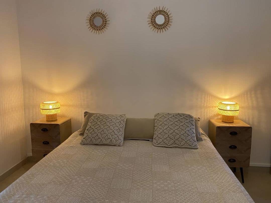 Chambre cosy avec lit double, chevets et lampes en rotin